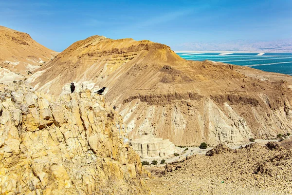 Yahudi Çölü 'nün antik dağları Ölü Deniz' i çevrelemektedir. İsrail ve Ürdün kıyıları arasındaki tuzlu deniz suları. Rüzgarlı bir bahar günü. Siren bulutları mavi gökyüzünde uçar 