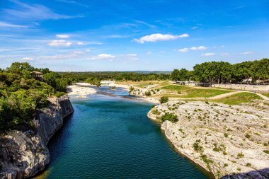  Fransa 'ya ilginç bir yolculuk. Güneşli bir günde sığ Gardon Nehri. Antika köprü - su kemeri - Pont du Gard 