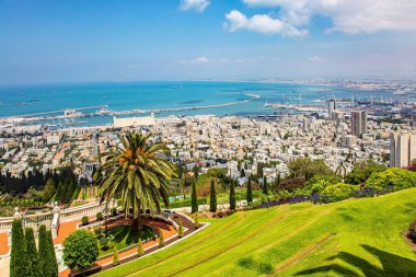 İsrail. Muhteşem renkli bahçeler, çiçek yatakları, selvi ağaçları ve yeşil çimenler turistleri çekiyor. Mount Carmel 'den Haifa' nın uluslararası limanına. Deniz kenarında güneşli bir gün. 