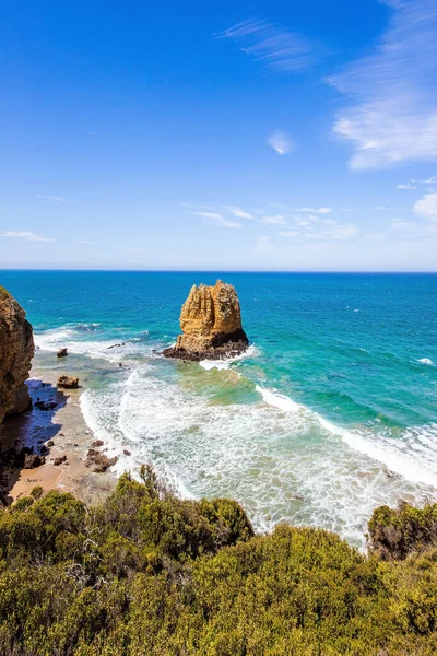 Okyanus sörfünün köpüğündeki sahil kayaları. Pasifik kıyısı ve kumlu sahil. Avustralya 'ya harika bir yolculuk. Güney Yarımküre. 