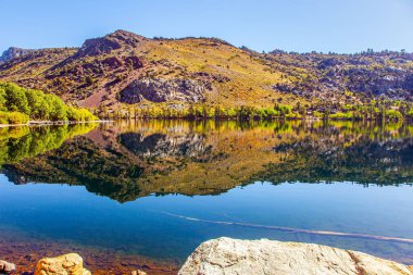 Muhteşem Gümüş Göl, California 'nın dağlarında. ABD 'nin batısına sonbahar yolculuğu. Suyun pürüzsüz yüzeyi gökyüzünü, dağları ve ormanları yansıtır.. 