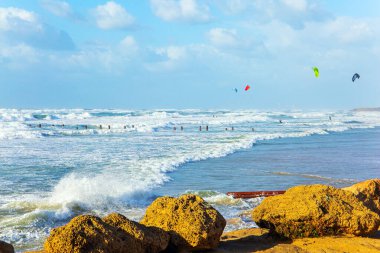 Kış sörfü kar beyazı köpükle havalanır. Büyük taşlar sahili büyük fırtına dalgalarından korur. Tel Aviv 'de toprak seti. İsrail. Gün batımı. Akdeniz 'de rüzgarlı güneşli bir gün. 