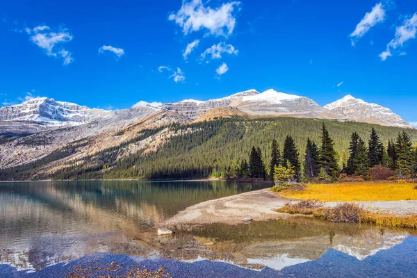 カナダだ ロッキー山脈 澄んだ紺碧の水と氷河湖の弓 晴れた秋の日 太陽と山は湖の滑らかな水に反映されます — ストック写真