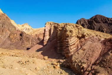 Kasım günü. Eilat Dağları 'ndaki toprak yol. Renkli peyzaj oluşumları. İsrail dağlarındaki yıpranmış kumtaşı.