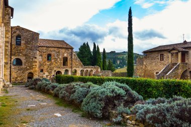 San Antimo 'nun ortaçağ muhteşem manastırı. Manastırın etrafındaki yeşil park. Resimli Toskana usulü. Aktif, kırsal ve fotoğraf turizmi kavramı