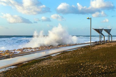 Tel Aviv 'de toprak seti. İsrail. Akdeniz kıyısında rüzgarlı ve güneşli bir gün. Gün batımı. Güçlü kış sörfü kar beyazı köpükle kalkıyor. Akdeniz 'de kış fırtınası