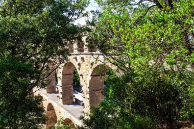 Pont du Gard, Roma 'nın en uzun su kemeridir. Su kemeri Pont du Gard yoğun yaprak döken ormanlarla kaplı tepeleri birbirine bağlar. Parlak güneşli bir gün. Fransa 'ya ilginç bir yolculuk.. 
