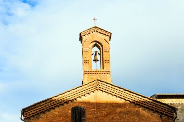 Çan kulesinin tepesinde haç var. Toskana 'ya kış gezisi. Siena 'nın eski şehir merkezi. Gün batımı