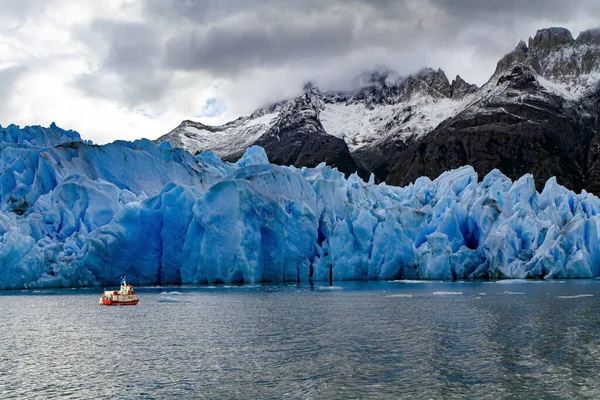 灰冰川 Gray Glacier 是智利巴塔哥尼亚的一座蓝色冰川 游客乘坐的小船漂浮在冰山之间 巨大的冰山已经从灰色冰川上断裂 漂流过湖面 灰色的大冰块 — 图库照片