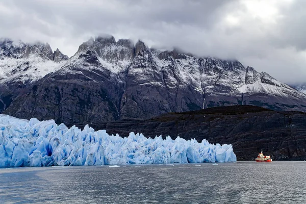 灰色の氷河はチリのパタゴニアにある青い氷河です 灰色の偉大な氷 観光客とボートは氷山の間に浮かぶ グレー氷河から巨大な氷山が崩壊し 湖を渡って漂流しています — ストック写真