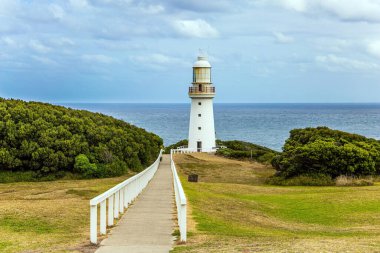 Deniz fenerine giden yol parmaklıklarla çevrili. Büyük Okyanus Yolu Avustralya 'nın Pasifik kıyısı boyunca uzanır. Okyanus kıyısındaki muhteşem deniz feneri. 