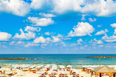Akdeniz 'de. Modern şehir Tel Aviv. Turistler için rahat kırmızı güneş pansiyonları. Çok renkli şemsiyeler sıcak güneşten korur. Güzel bir sahilde güneşli bir gün.. 
