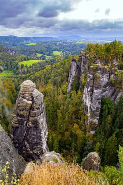 Bastei 'nin Elbe Nehri üzerindeki resimli kumlu uçurumları. Almanya. Bulutlu bir sonbahar günü. Sakson İsviçre 'ye romantik bir gezi.