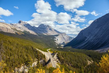 Grandiose mountain landscape. The Rocky Mountains of Canada.  Indian summer in Jasper Park. Magnificent highway among coniferous forests. Travel and photo tourism concept