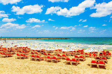 Muhteşem modern şehir Tel Aviv. Akdeniz 'de. Güzel bir sahilde güneşli bir gün. Sıcak denizin kıyısındaki turistler için rahat kırmızı güneş pansiyonları.