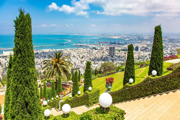 Muhteşem renkli bahçeler, çiçek yatakları, selvi ve yeşil çimenler hacıları ve turistleri cezbediyor. Mount Carmel 'den Haifa' nın uluslararası limanına. İsrail. Deniz kenarında güneşli bir gün