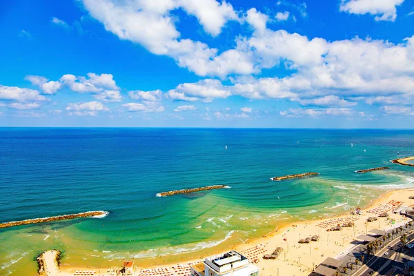 Tel Aviv 'deki muhteşem kumlu plaj. Akdeniz 'in mavi suları turistleri çeker. Dalgalar dalgaları azaltır. İsrail. Fotoğraf yüksek katlı bir otelin çatısından çekildi.. 