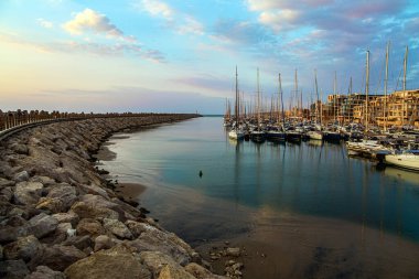 Marina, Herzliya, İsrail 'de yat, tekne ve küçük tekneler için limandır. Akdeniz 'de akşam alacakaranlığı. Yat limanını fırtınalardan koruyan dalgakıran boyunca yürü 