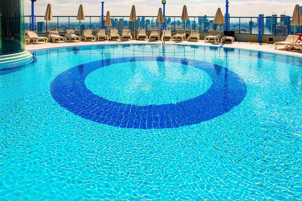 高層ホテルの屋上プール プールの周りでは サンラウンジャーがお客様を待っています イスラエルのテルアビブだ プールの丸いボウルは透明な水で満たされています — ストック写真