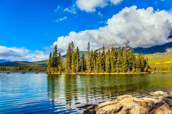 松やモミの木が生い茂る絵のような小さな島 ピラミッド湖だ ピラミッド山は積雲に覆われている カナダのロッキー山脈で寒い晴れた日 — ストック写真