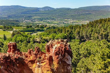 Pigment taş ocağının eskiden olduğu yerde tuhaf okçuklar var. Kayalar ormanla kaplı. Roussillon köyü. Muhteşem güneşli Provence 'a git. Fransa