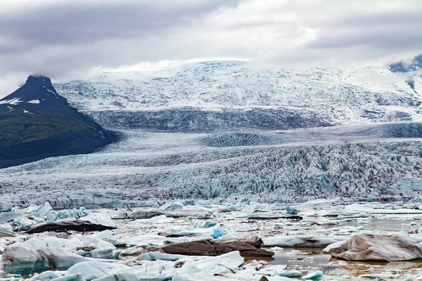 Jokulsarlon冰川泻湖 身穿蓝色夹克的女人喜欢这美丽的风景 冰岛北部一个迷人的风景秀丽的泻湖 寒冷山脉中的冰川和冰山 — 图库照片