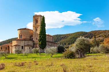 Selvi, bahçe ve üzüm bağları arasında muhteşem bir ortaçağ manastırı. Güzel bir Hint yazının yeşil, sarı ve turuncu renkleri. İtalya. Öğlen. Güzel Toskana. 