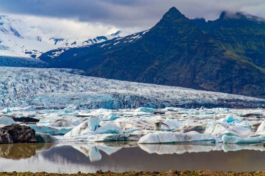 Kuzey Kutbu 'nda soğuk bir yaz. Jokulsarlon buzul gölü. İzlanda 'nın kuzeyindeki görkemli manzaralı göl. Soğuk dağların arasındaki buzullar ve buzdağları. İzlanda. 
