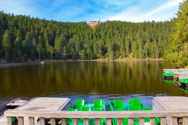 Mummelsee gölü, sık ve yeşil Kara Orman ile çevrilidir. Tahta geçitler neredeyse gölün ortasına kadar getirilir. Almanya 'ya sonbahar gezisi. Gün batımı