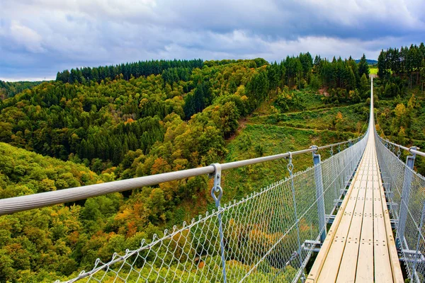 suspension bridge in Germany. Hunsrck region in Rhineland-Palatinate. Picturesque bridge over the valley of the Mersdorf stream. Windy and cold autumn day