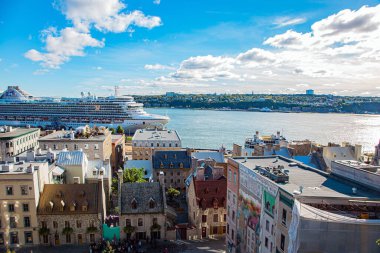 Snow-white ocean passenger liner in the port of Quebec. Beautiful sunset in the seaside city. Ancient architecture of Quebec Historic Center. Unforgettable trip to Canada.