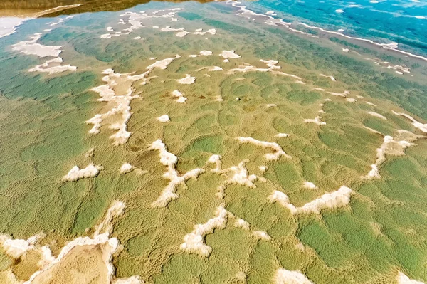 Dead Sea. Israel. The clear green water of the salty sea. Salt deposits are visible on the seabed. Cold sunny winter day. Landscape photographed by a drone from a aerial view