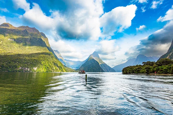 Tourist boat in the smooth water of the Milford Sound. New Zealand. South Island. The magical nature of the southern hemisphere. Fiordland park.