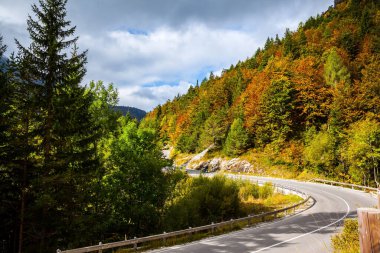Julian Alpleri 'nin tepesindeki asfalt yolda. Gün batımı, büyük bir bulut yaklaşıyor. Slovenya 'da Altın Sonbahar. Avrupa