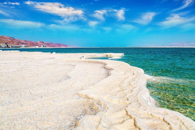 Eşsiz Ölü Deniz. Orta Doğu 'daki drenajsız tuz gölü, dünyanın en tuzlu gölü. Buharlaşmış tuz, suda tuhaf kristal şekiller oluşturur. İsrail kıyıları, Şubat günü. 