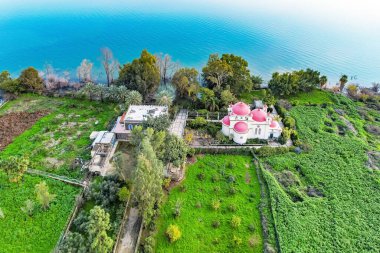 Kinneret Gölü kıyılarında sakin bir kış günü. Capernaum 'daki 12 Havarinin Yunan Ortodoks Manastırı. Kilisenin etrafındaki tropik park. Fotoğraf bir İHA 'dan çekildi. İsrail.