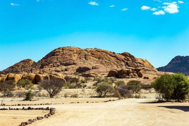 Afrika. Spitzkoppe, Namibya 'da küçük bir kaya yığınıdır. Spitzkoppe 'un muhteşem kırmızı-turuncu kalıntıları. Uçsuz bucaksız Namibya çölünün ortasında devasa yuvarlak kayalar.