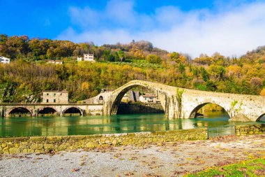 Toskana 'da. Borgo bir Mozzano. Serchio Nehri. Nehrin soğuk suyu Şeytan Köprüsü 'nün eski asimetrik kemerlerini yansıtır. Güneşli ve soğuk, rüzgarlı Aralık sabahı