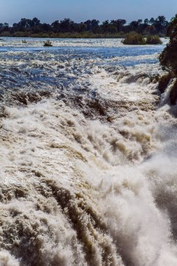 Baş döndürücü Victoria Şelalesi. Şelale Zambezi Nehri üzerinde, Victoria Ulusal Parkı 'nda Zambiya ve Zimbabwe arasındaki sınırda yer almaktadır. Yağmur mevsiminden sonra yolculuk. Ekstrem ve fotoğraf turizmi kavramı