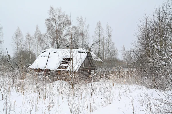 Oud landelijk huis onder witte sneeuw — Stockfoto