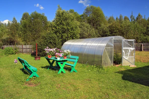 Meubles de jardin près de la serre en plastique — Photo