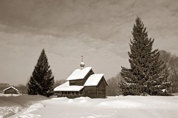 Dřevěná kaple v zimní vesnici, sépie — Stock fotografie
