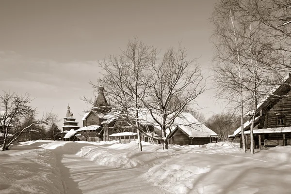 Drewniana kaplica w zimowej wiosce, sepia — Zdjęcie stockowe