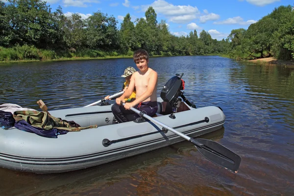 Deux garçons sur un bateau en caoutchouc sur la rivière — Photo