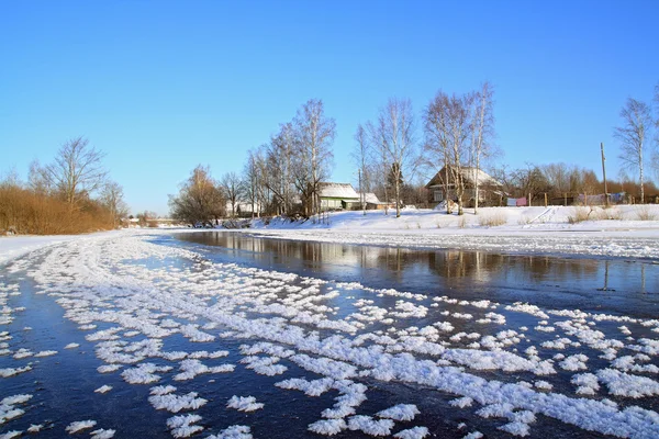 Pueblo de invierno en la costa río — Foto de Stock