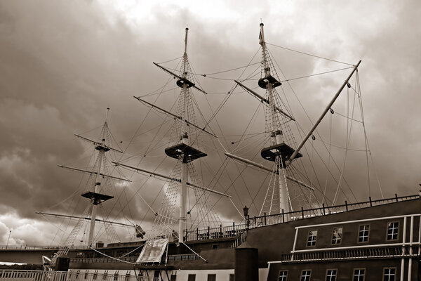 Старая шхуна на городской набережной, сепия
