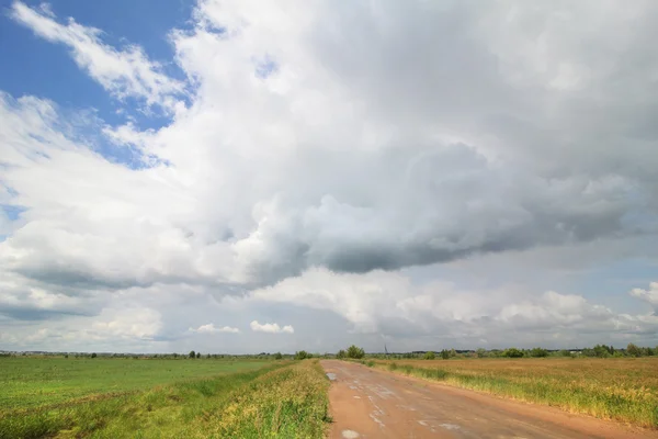 Nubes cúmulos sobre el camino en la estepa . —  Fotos de Stock