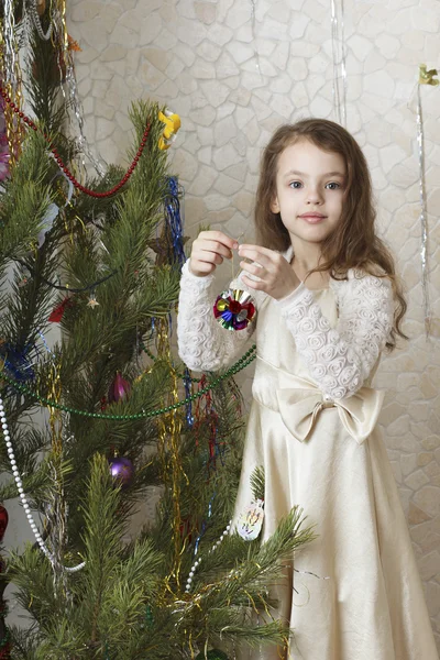 Krásná dívka zdobí vánoční strom. — Stock fotografie