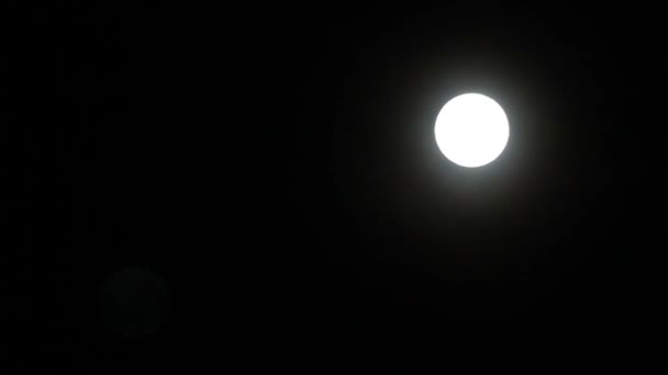 Lua cheia com um halo no fundo escuro do céu . — Vídeo de Stock