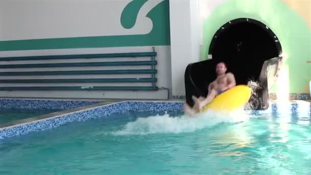 Uomo rotolato giù uno scivolo d'acqua su anelli di gomma . — Video Stock